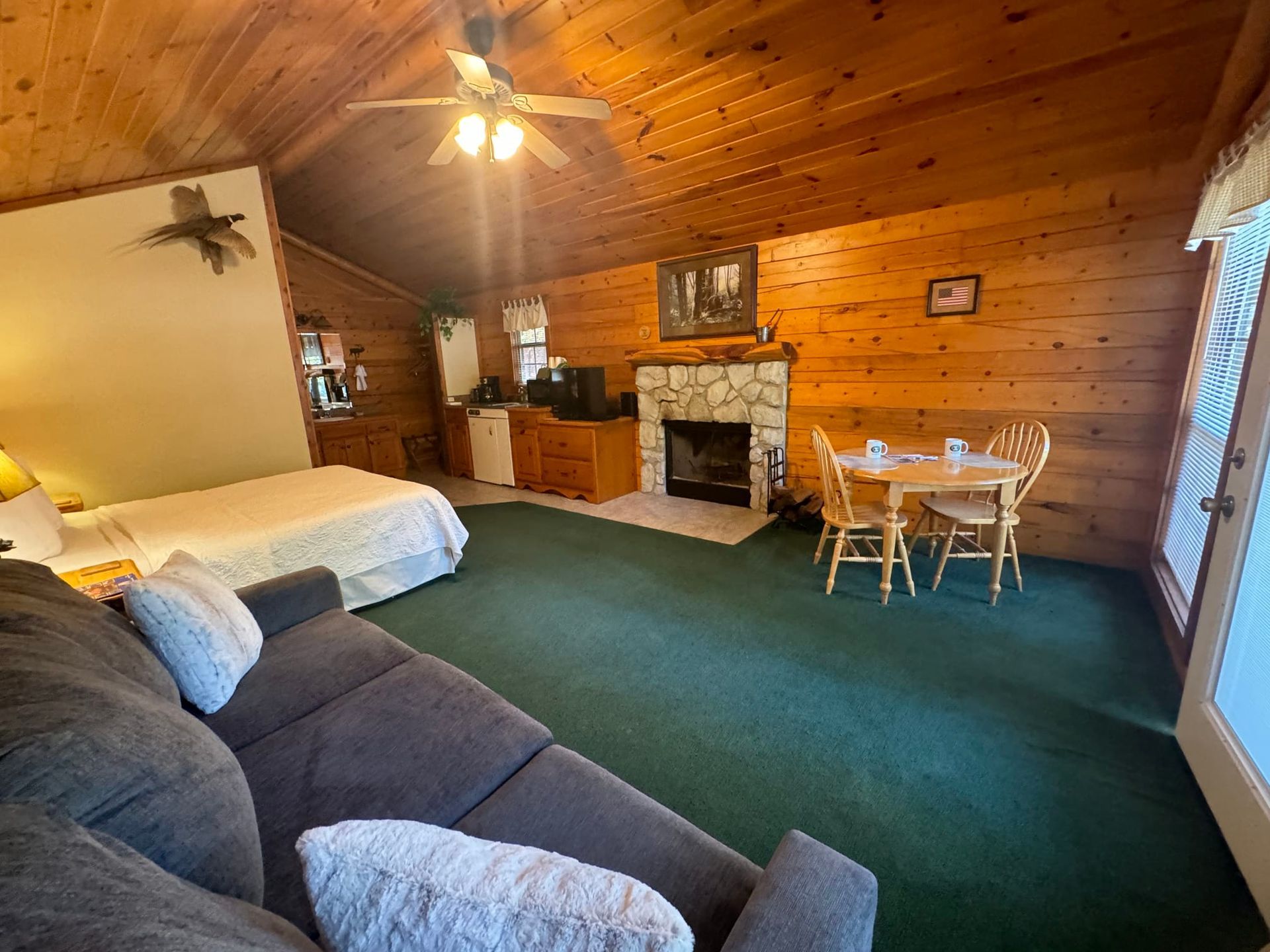 A living room with a couch , table , chairs and a fireplace.