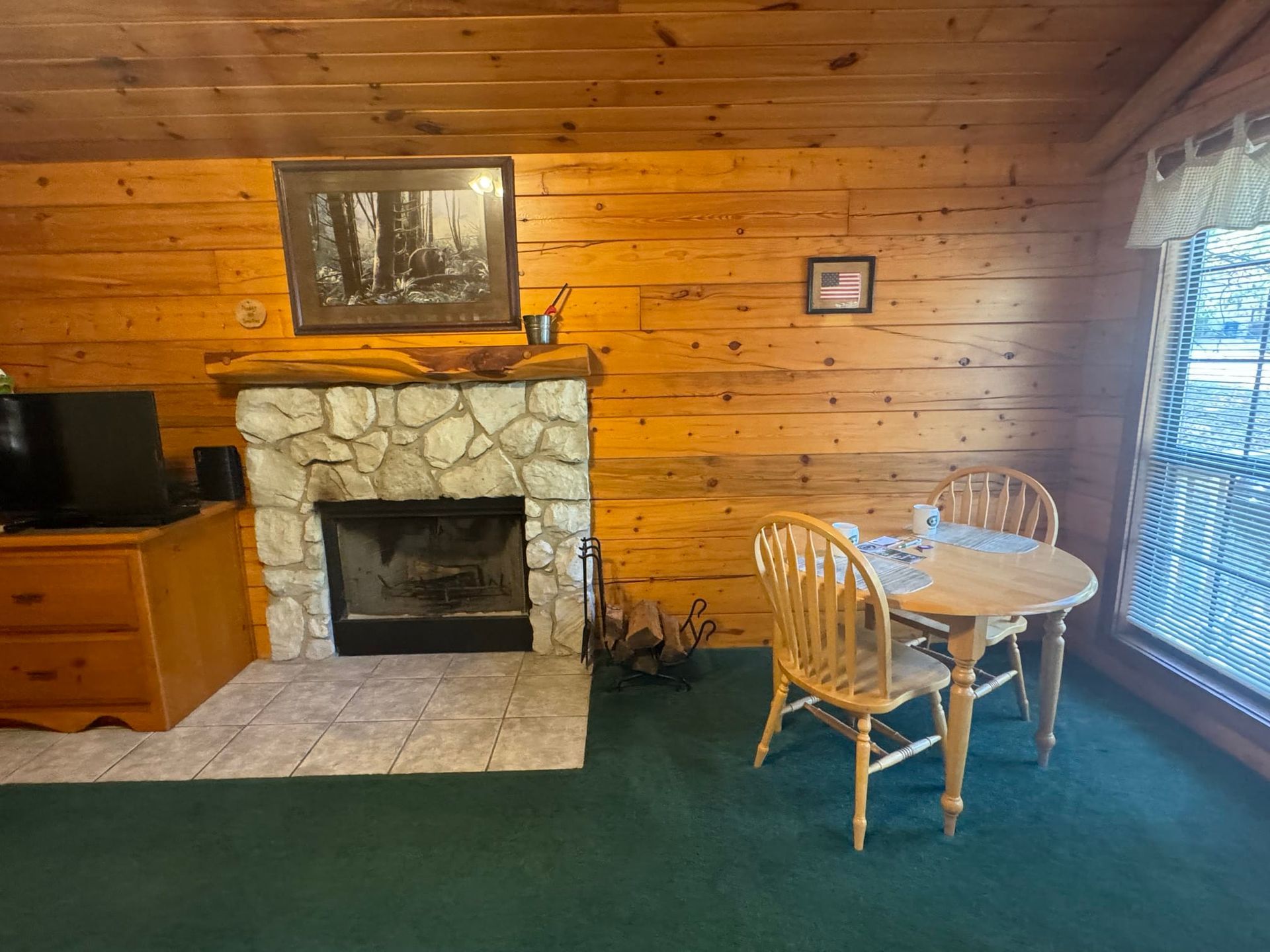 A living room with a fireplace and a table and chairs
