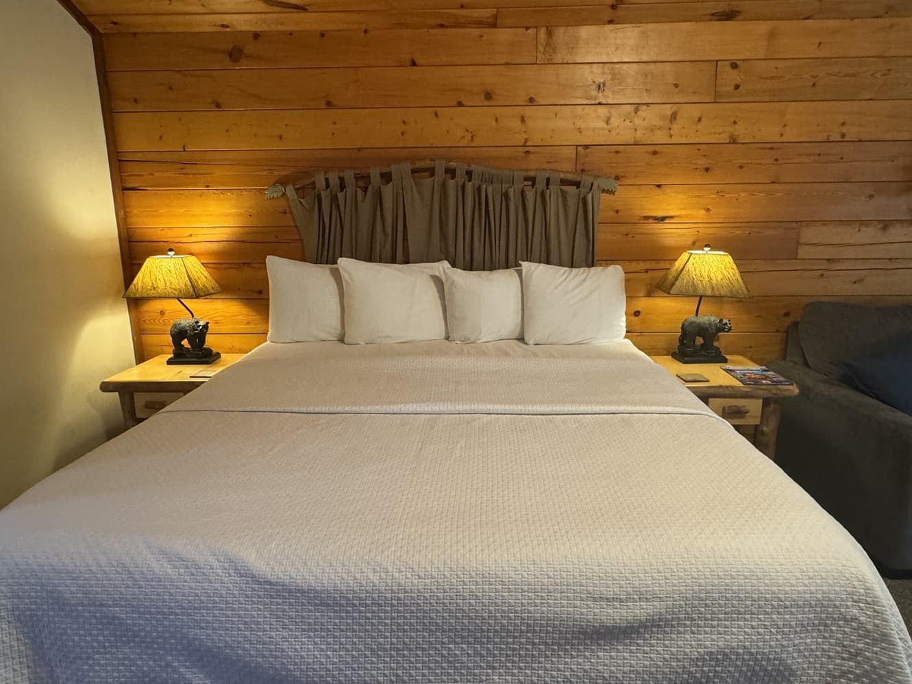 A bedroom with a bed , two lamps and a chair.