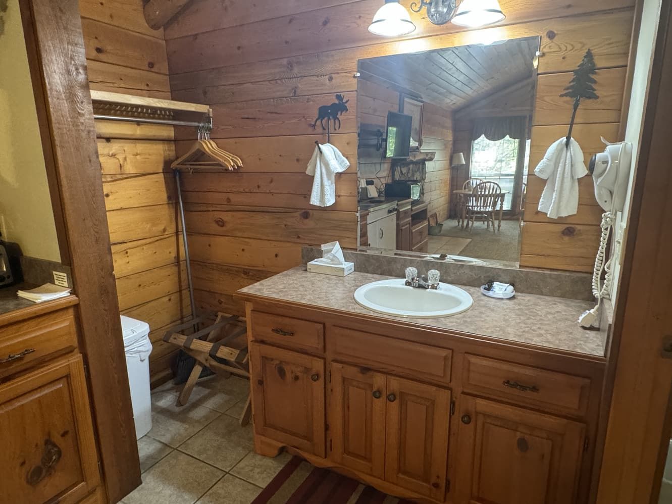 A bathroom in a log cabin with a sink and a large mirror.