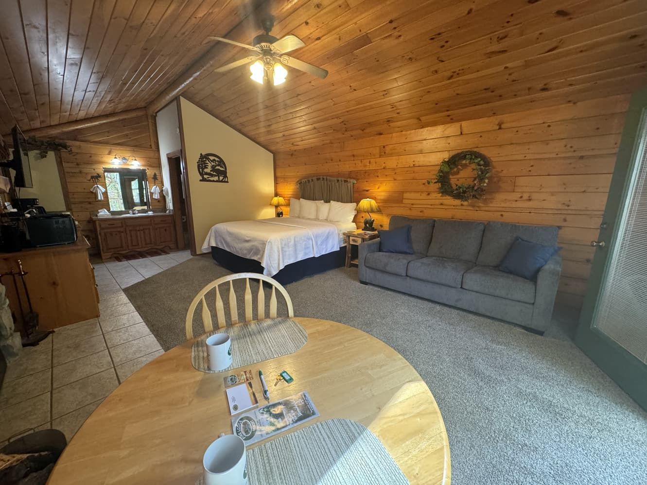 A living room with a bed , couch , table and chairs.