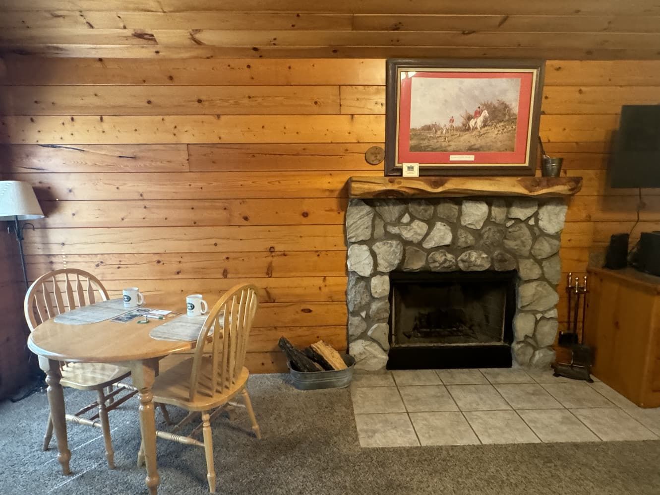 A living room with a table and chairs and a fireplace.