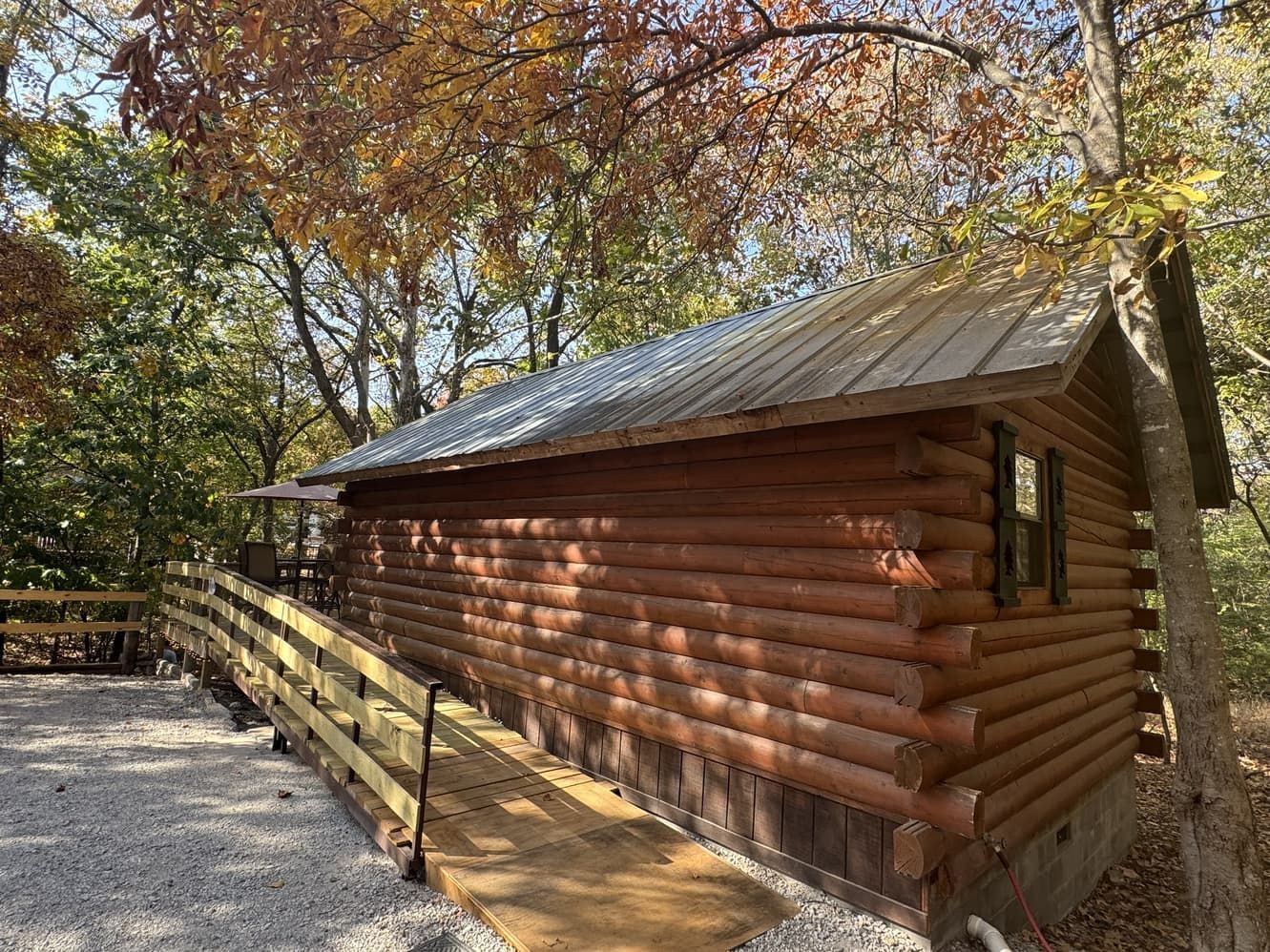 A log cabin with a ramp leading to it in the woods.