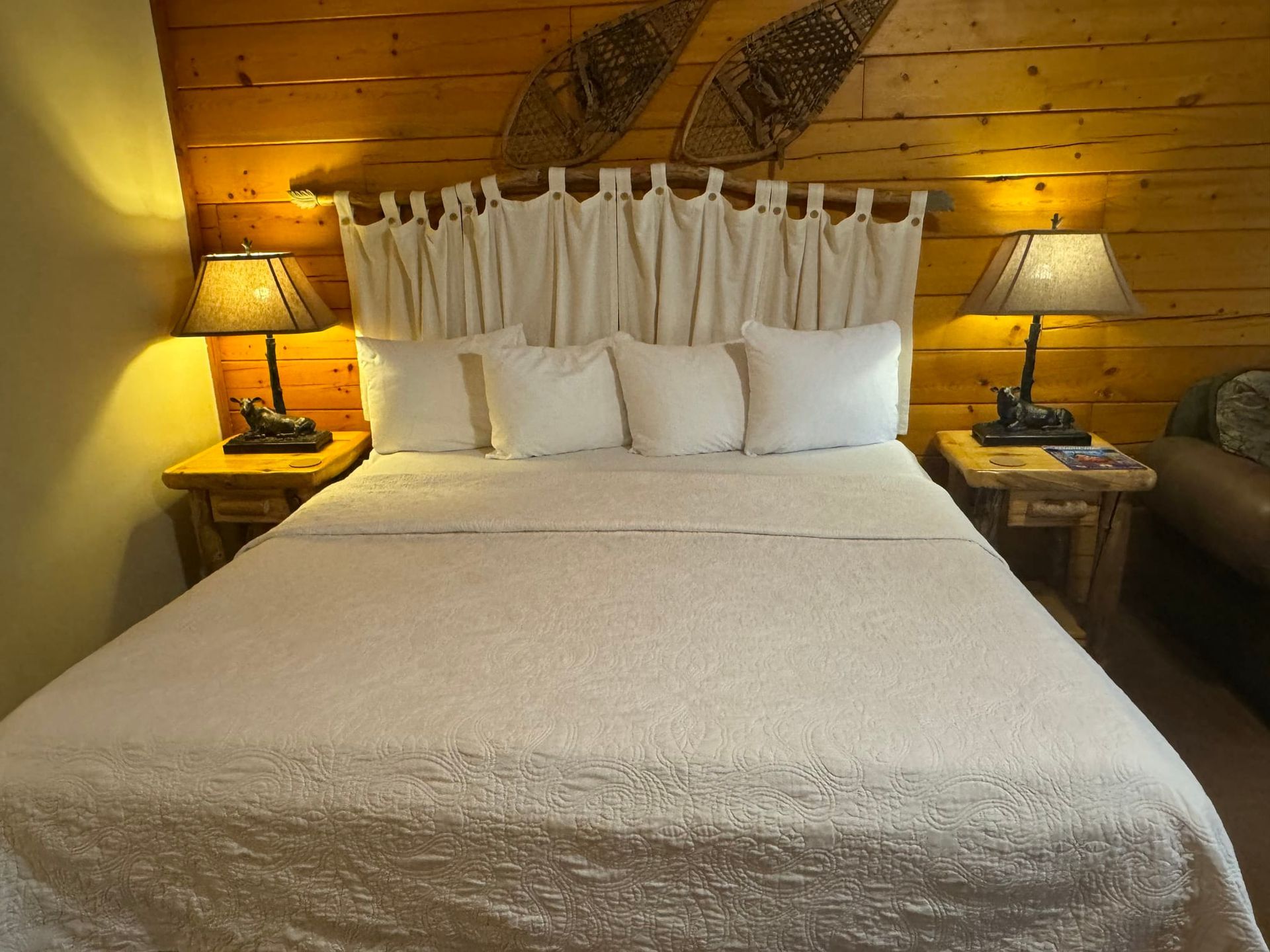 A bedroom with a bed and two lamps