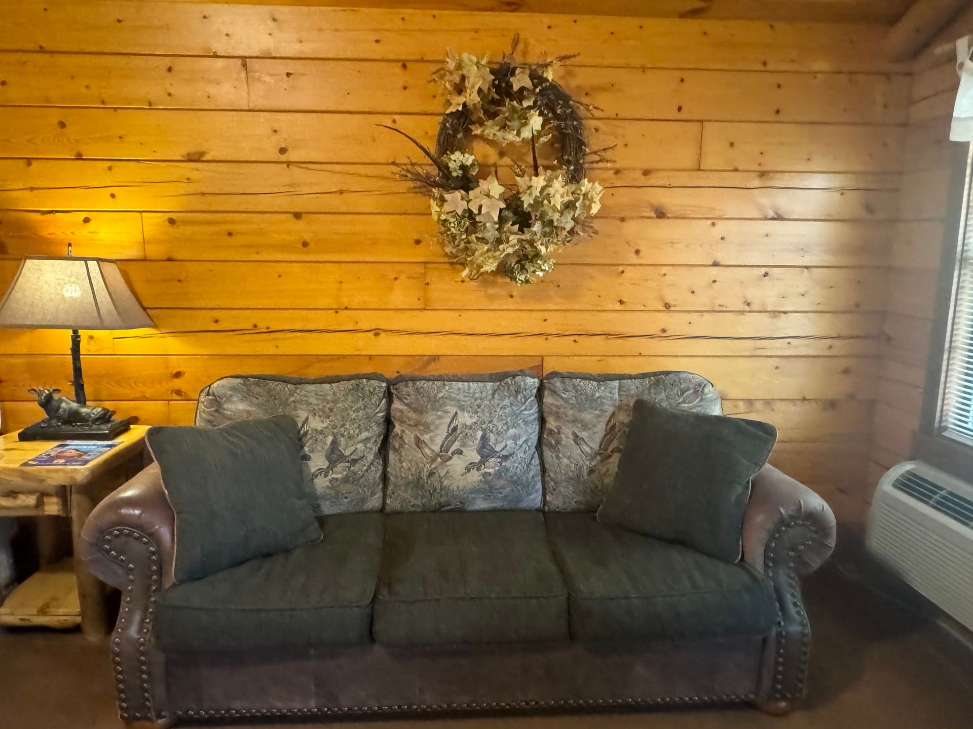 A living room with a couch and a wreath on the wall
