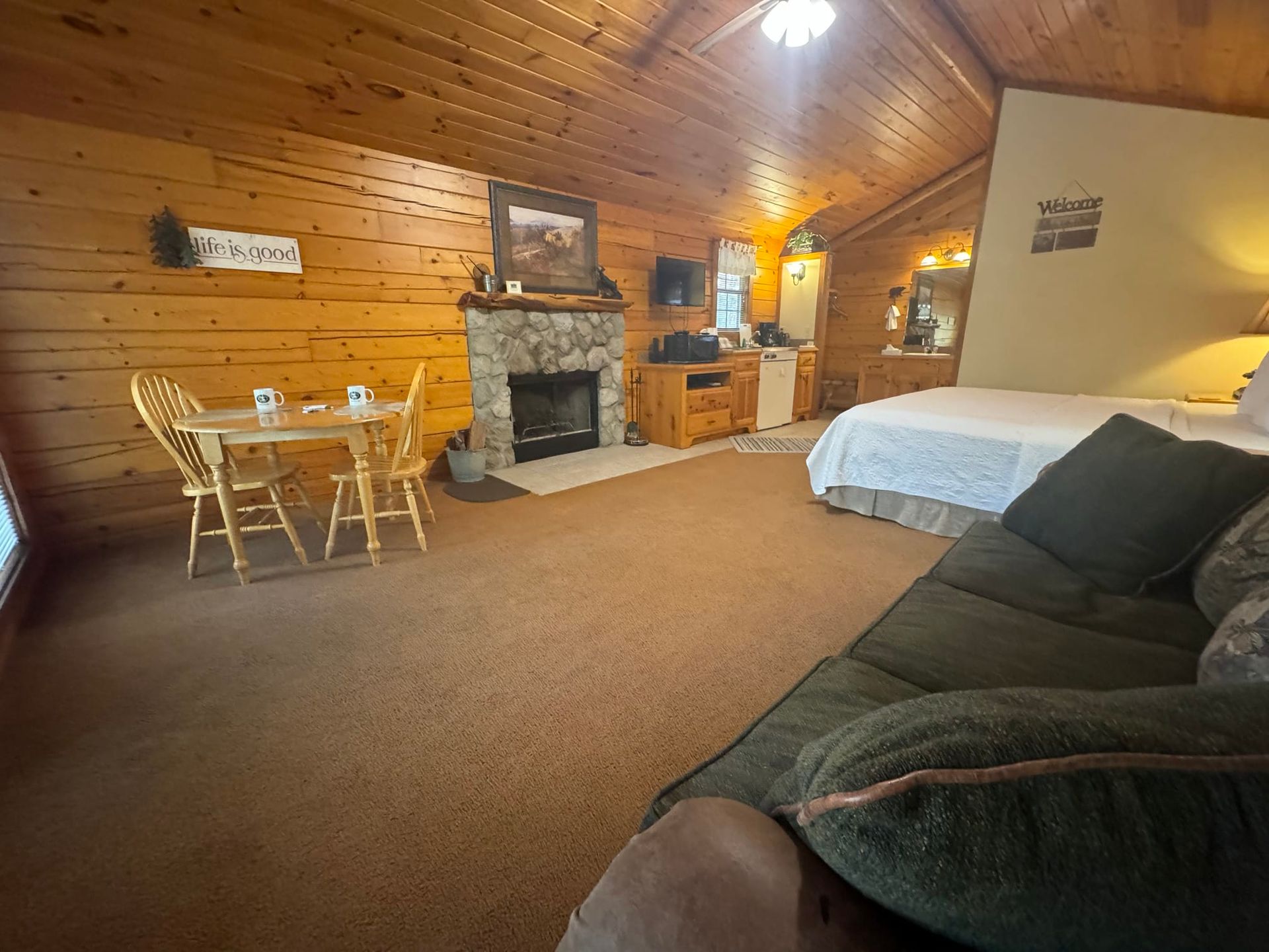 A living room with a couch , table , chairs and a fireplace.