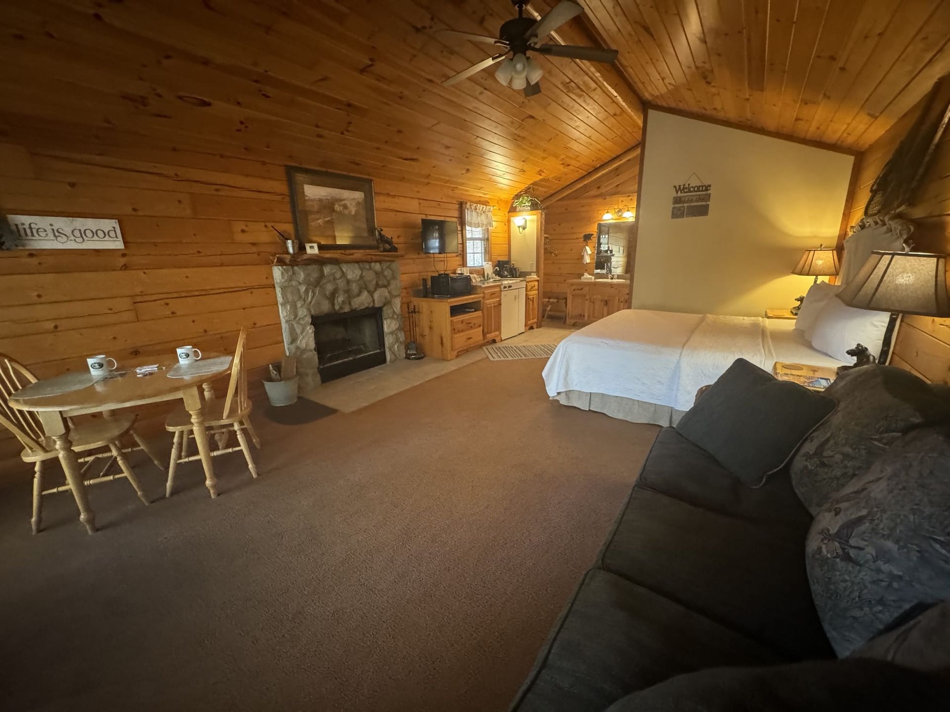 A bedroom with a bed , couch , table and chairs