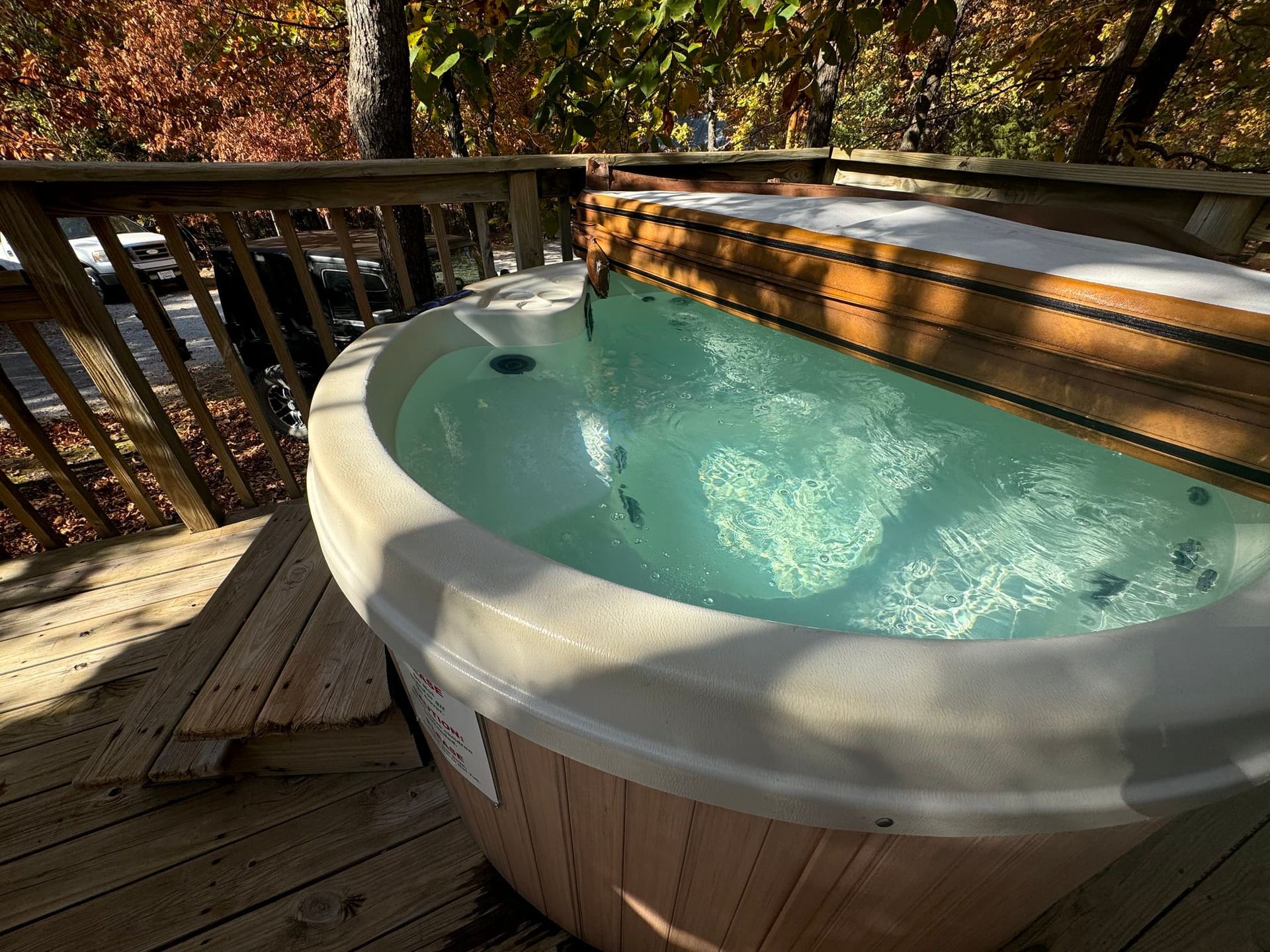A hot tub is sitting on top of a wooden deck.