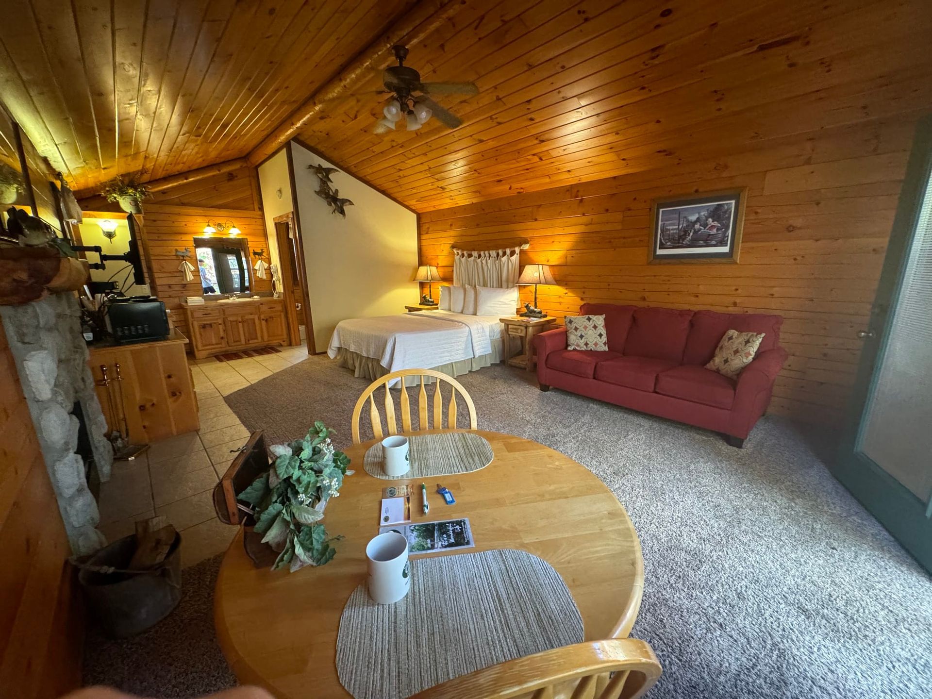 A living room with a bed , couch , table and chairs.