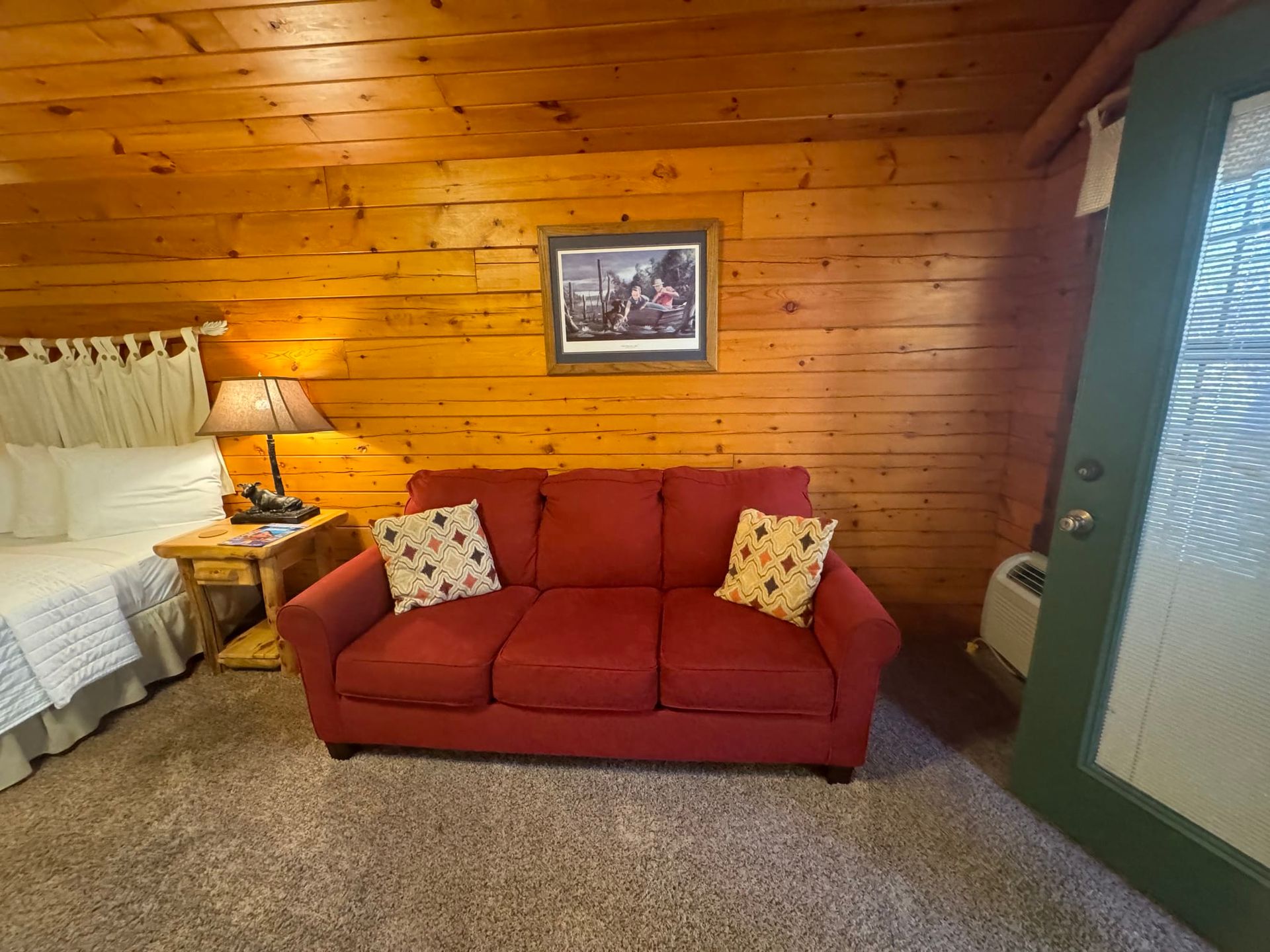 There is a red couch in the middle of the room.
