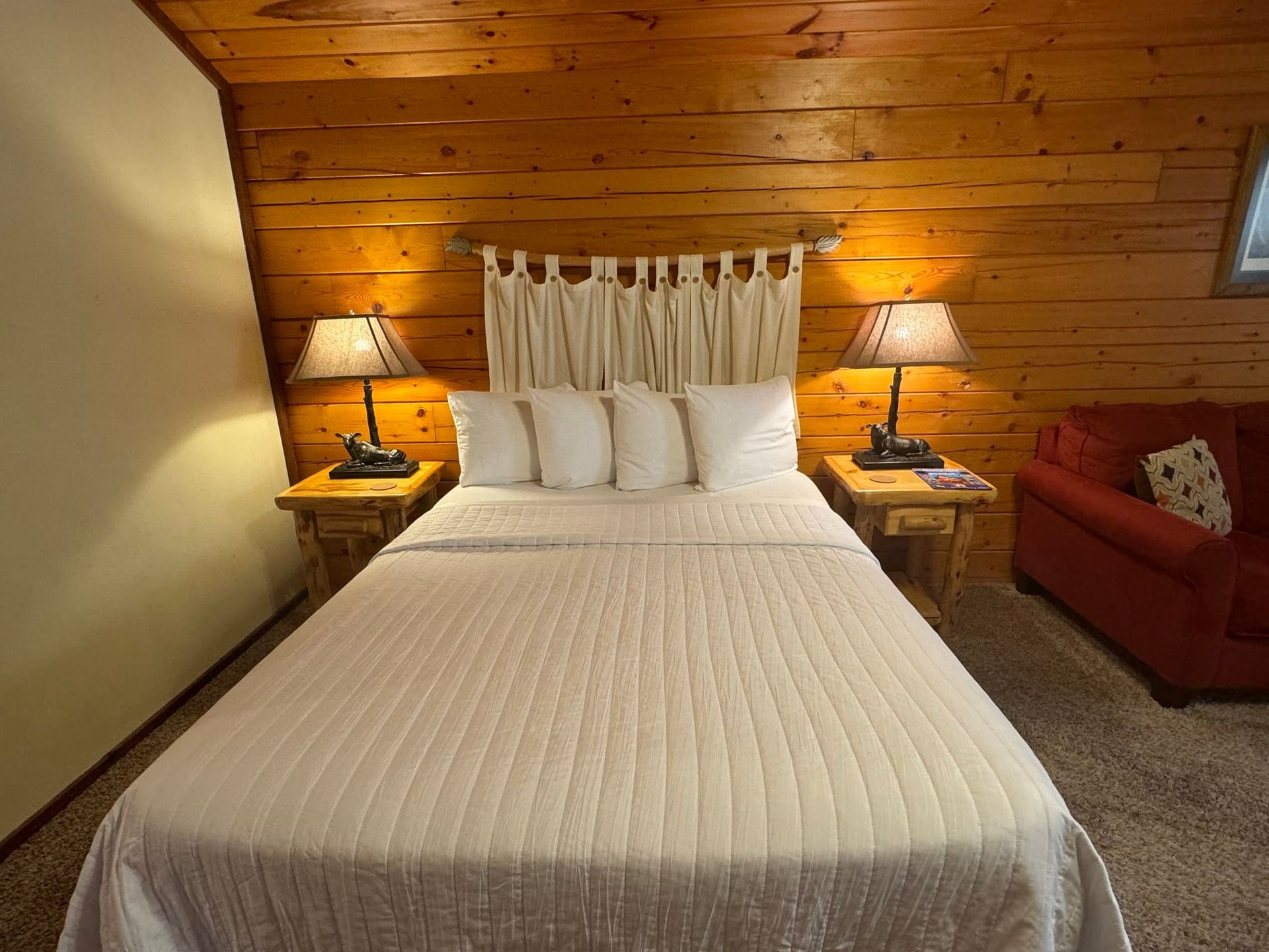 A bedroom with a bed , two lamps and a chair