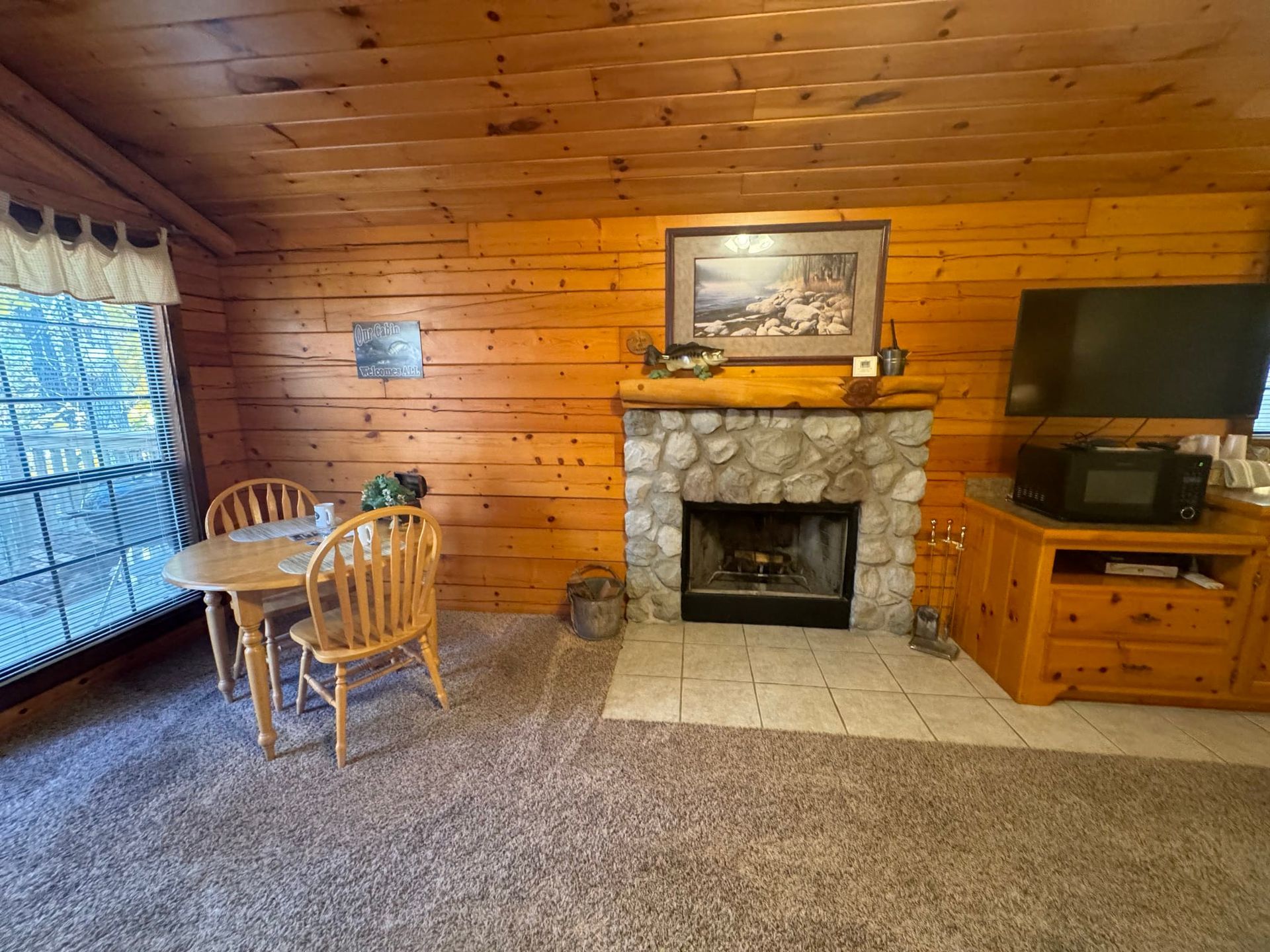A living room with a fireplace , table and chairs.
