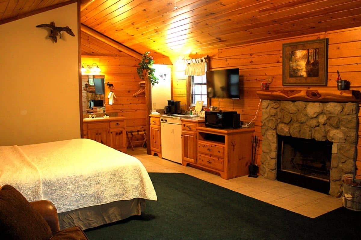 A bedroom with a stone fireplace and a bed