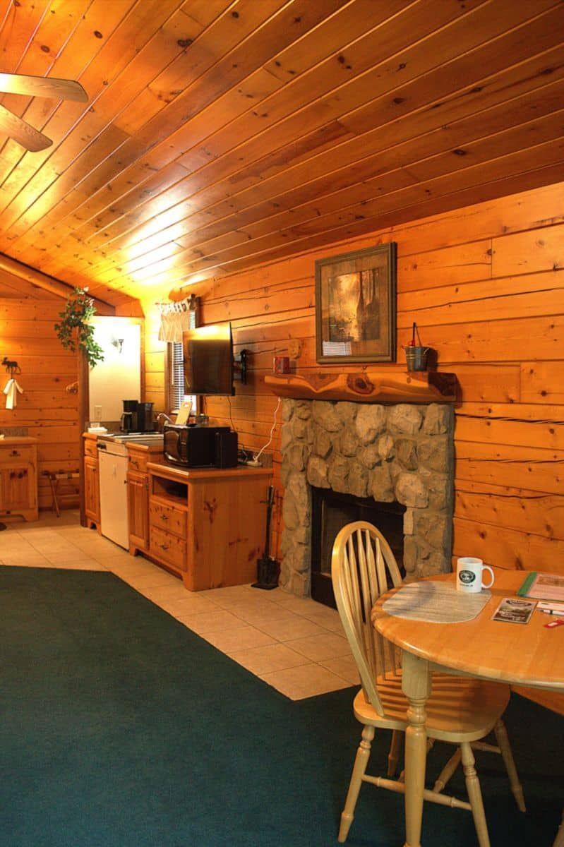A living room with a table and chairs and a fireplace