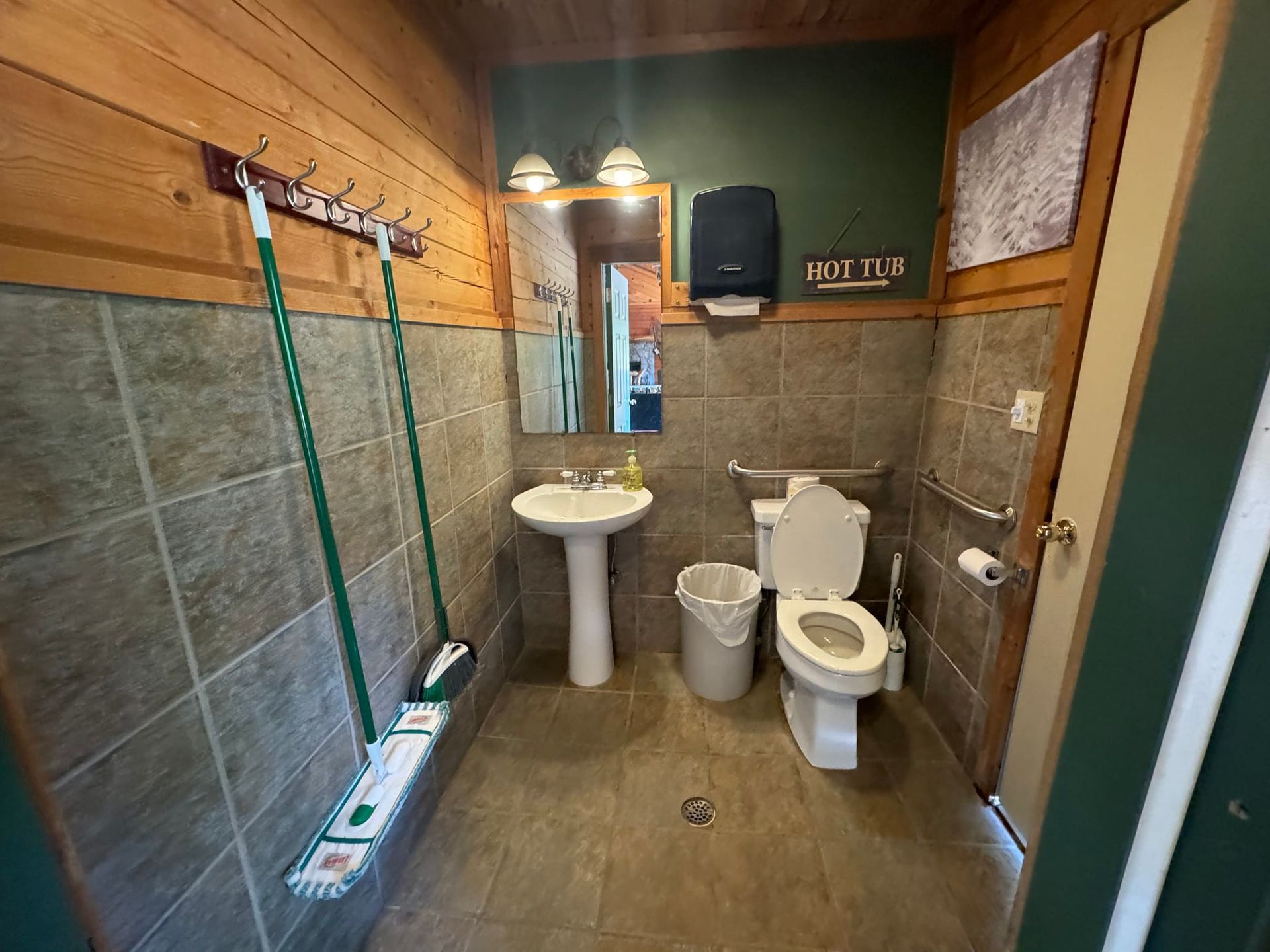 A bathroom with a toilet , sink and mirror.
