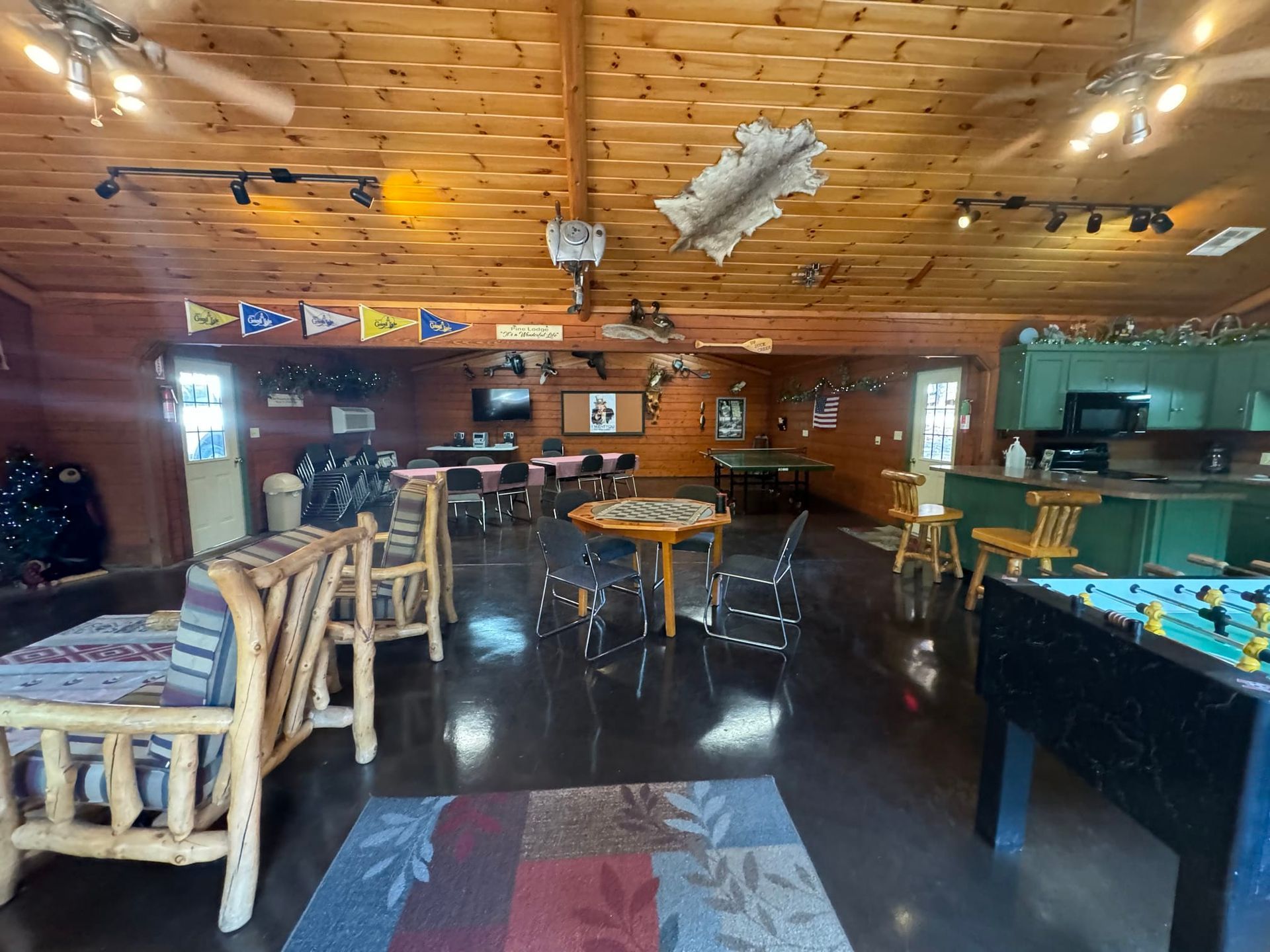 A large room with tables , chairs , and a foosball table.