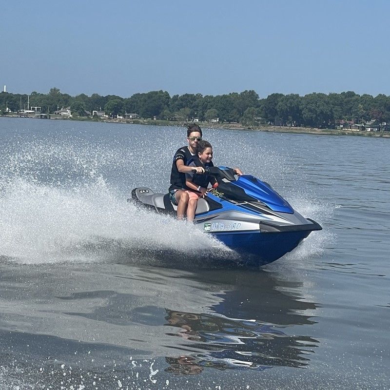 Two people are riding a jet ski on grand lake