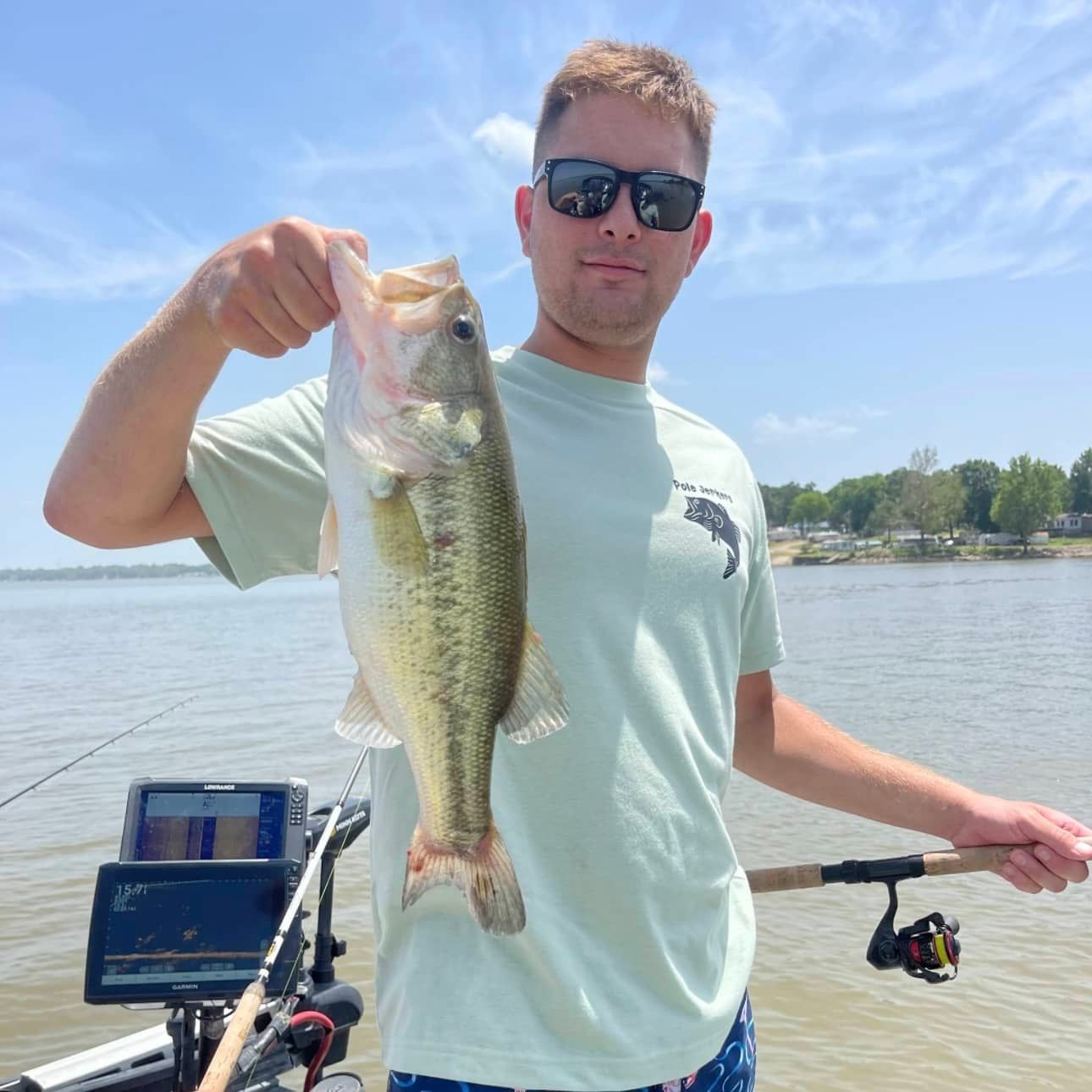 A man on a boat holding a large fish