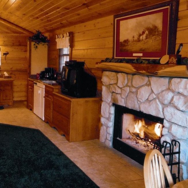 A living room with a fireplace and a picture on the wall