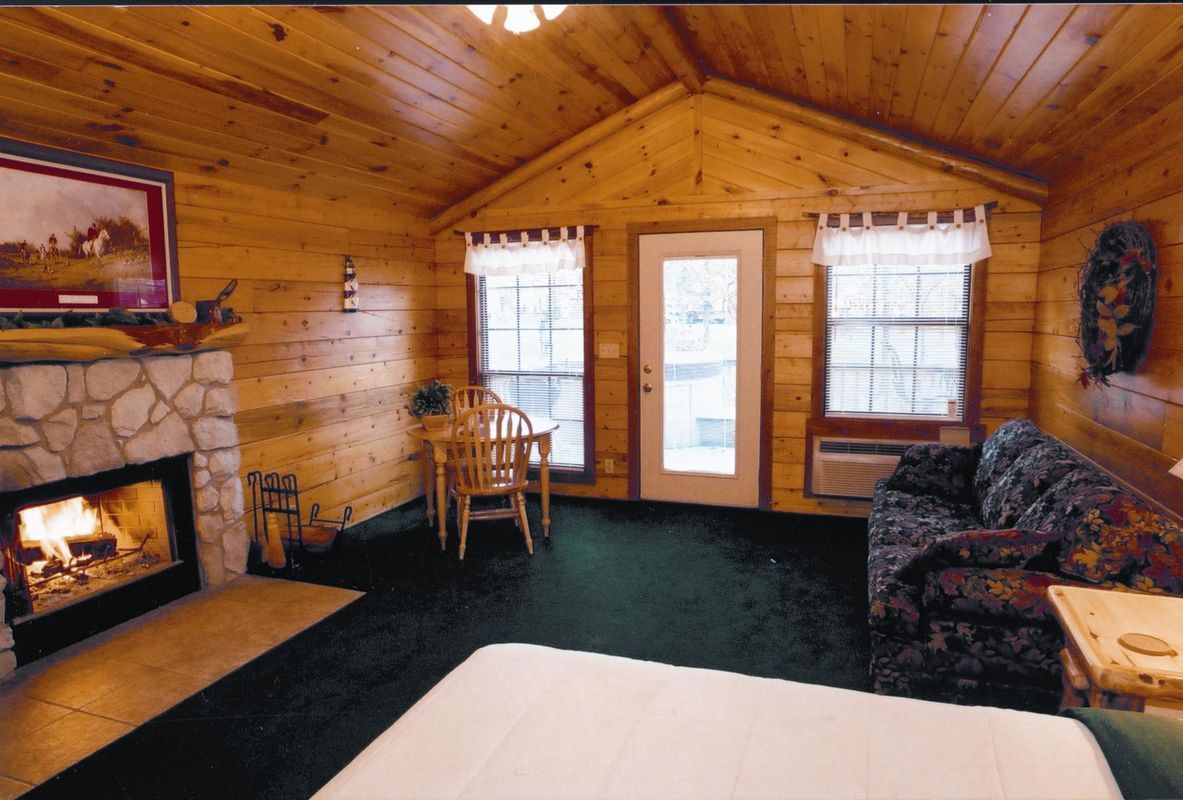 cabin interior with fireplace A living room with a fireplace and a couch