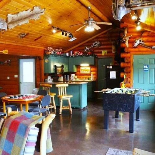 A living room in a log cabin with a foosball table