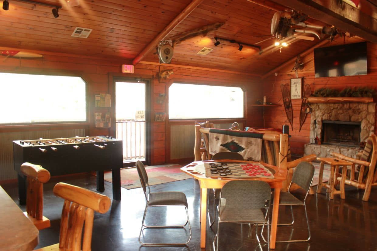 A room with tables and chairs and a foosball table