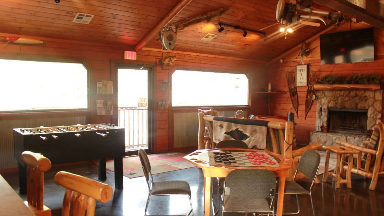 A room with tables and chairs and a foosball table