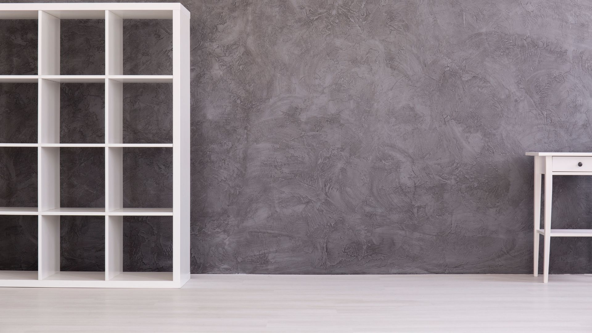 There is a shelf and a table in the room.