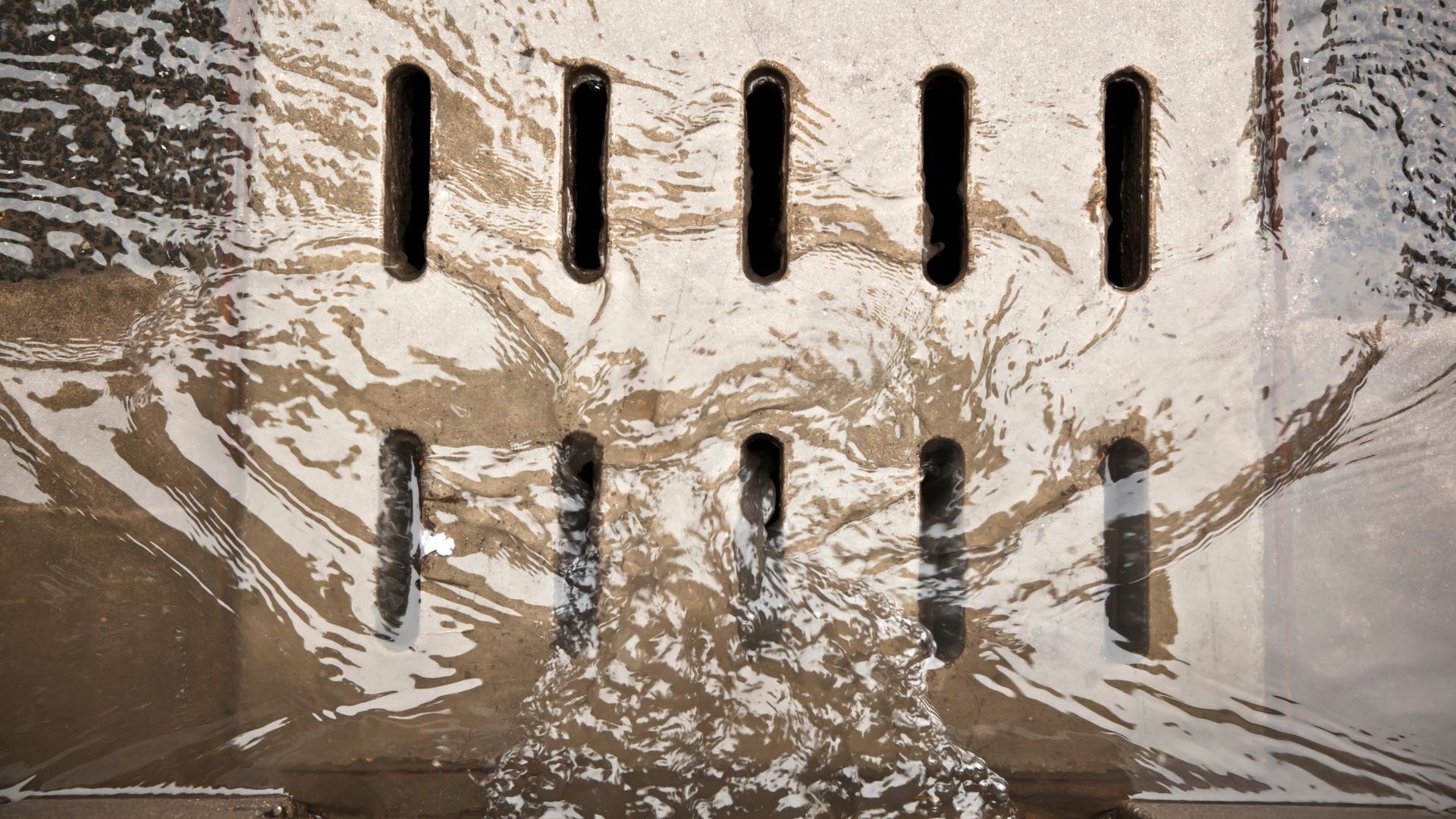 A close up of a drain with water coming out of it