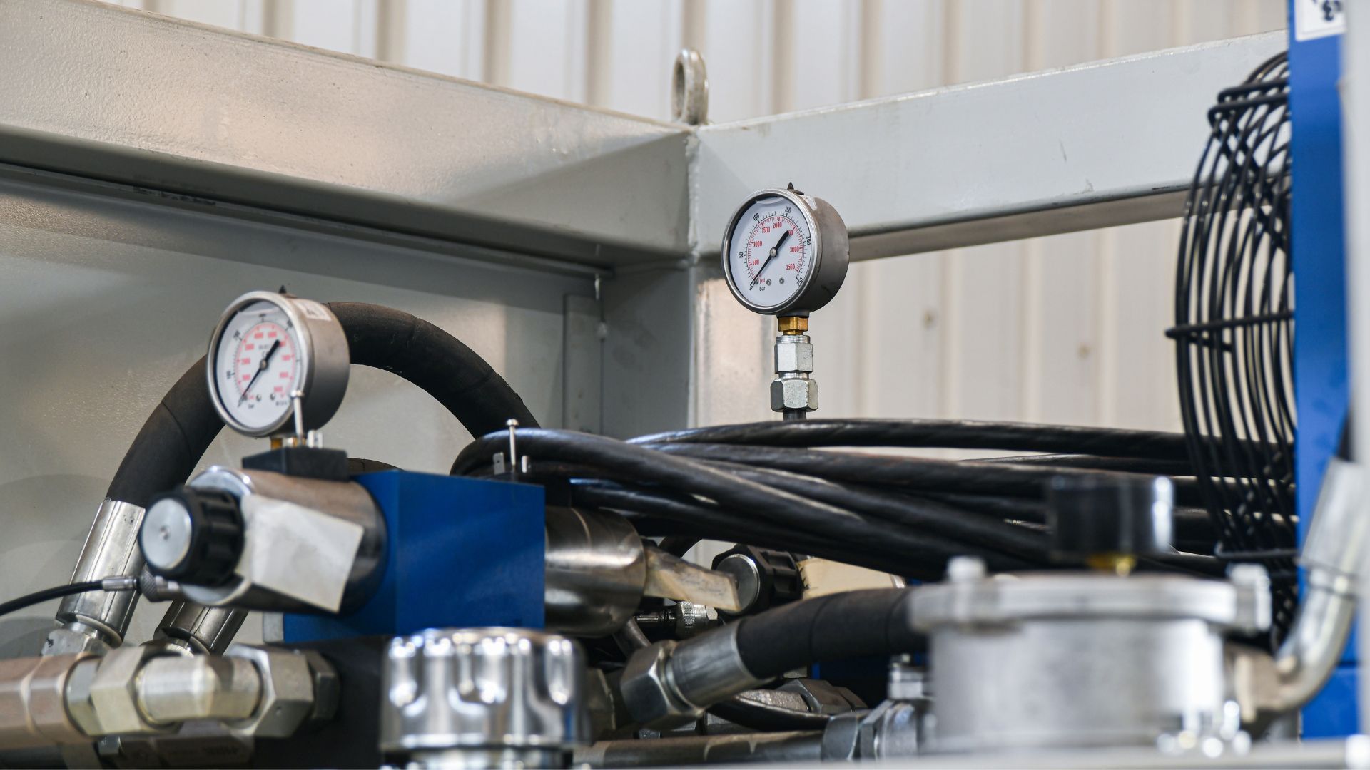 A close up of a machine with a fan and pressure gauges.