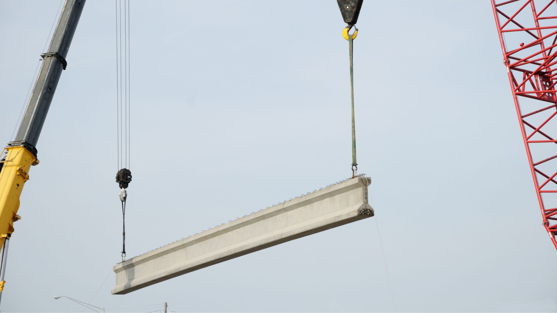 A large beam is being lifted by a crane.