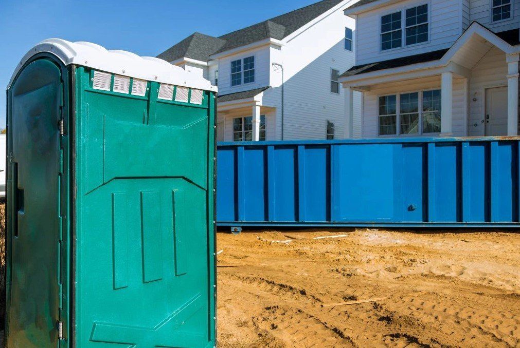 Single Porta Potty and blue Dumpster