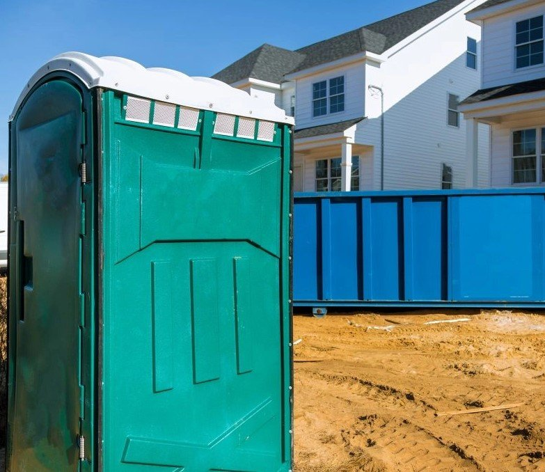 Single Porta Potty and Blue Dumpster