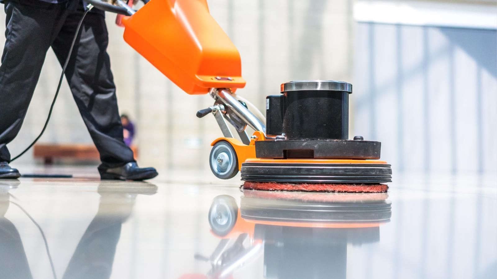 Professional using a machine to clean a stone floor