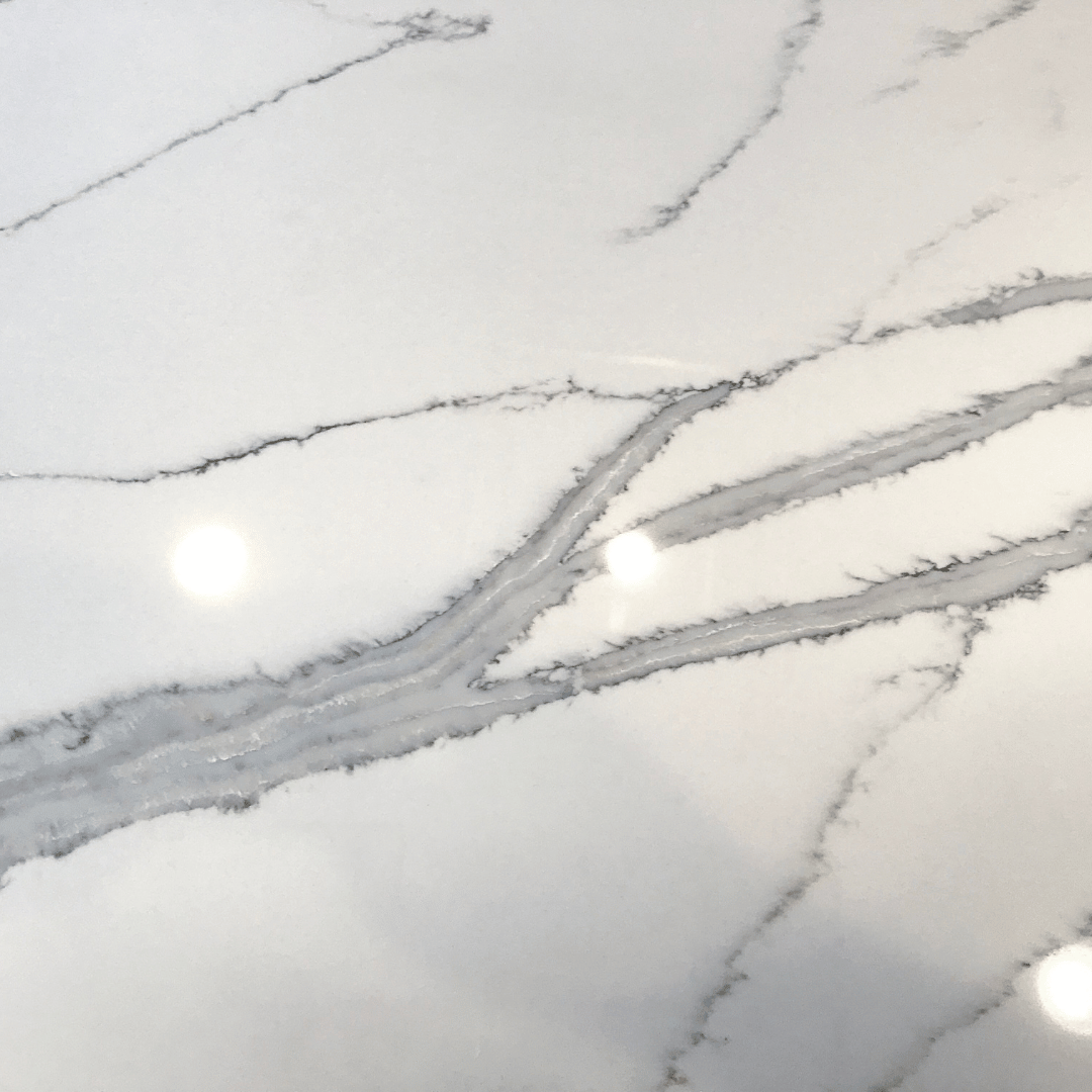 White countertop with gray veining and light reflections.