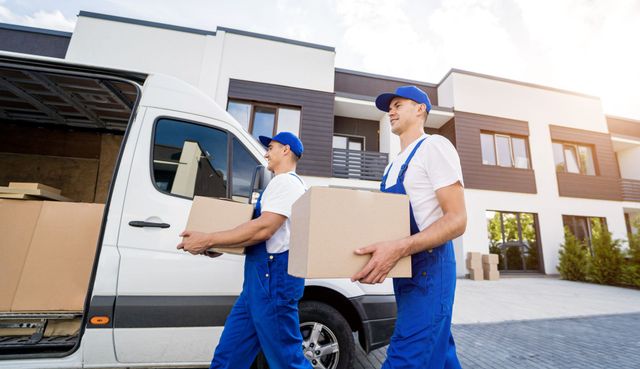 Two movers are carrying boxes out of a van.