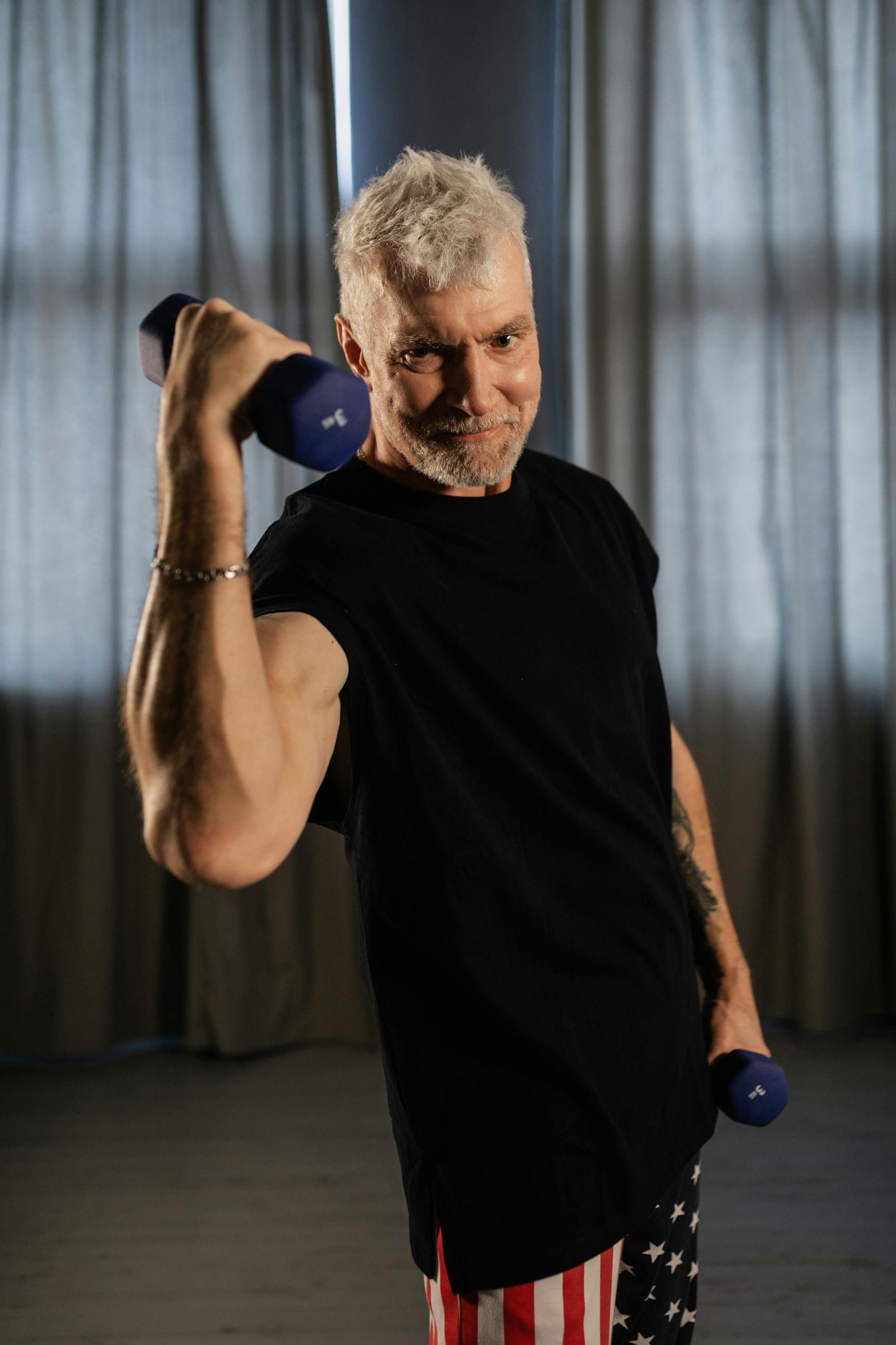An older adult smiling as they perform a simple strength exercise.