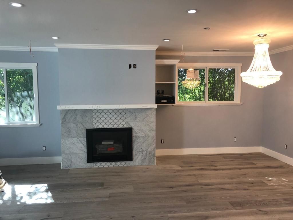 A living room with a fireplace and a chandelier
