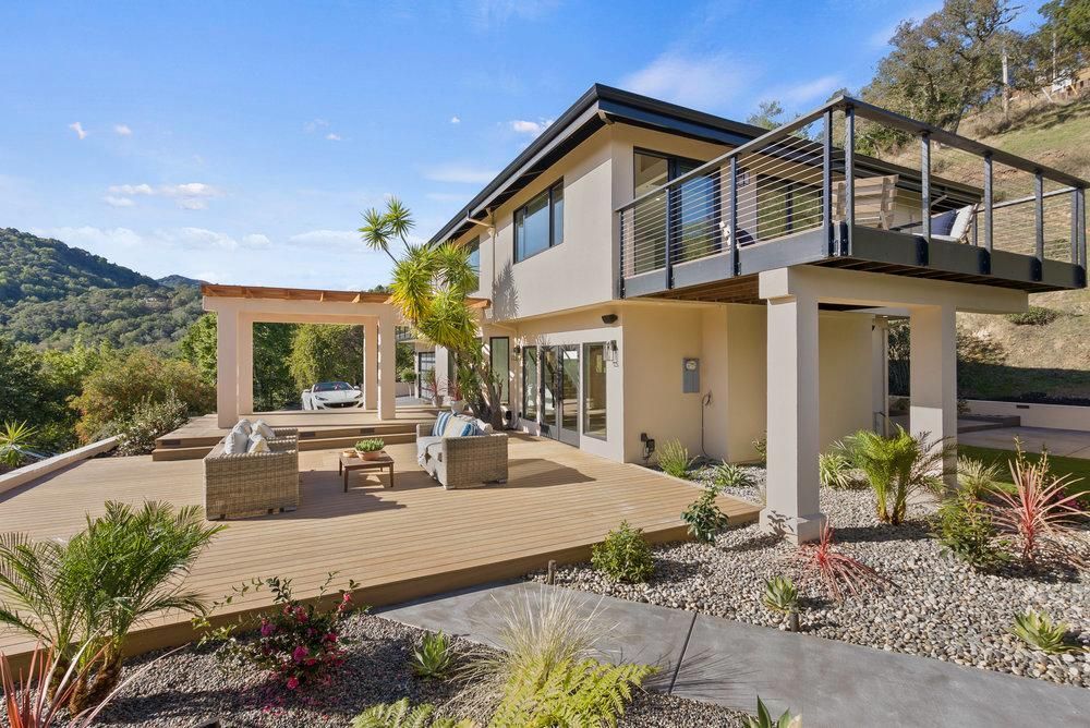 A large house with a large deck on top of it.