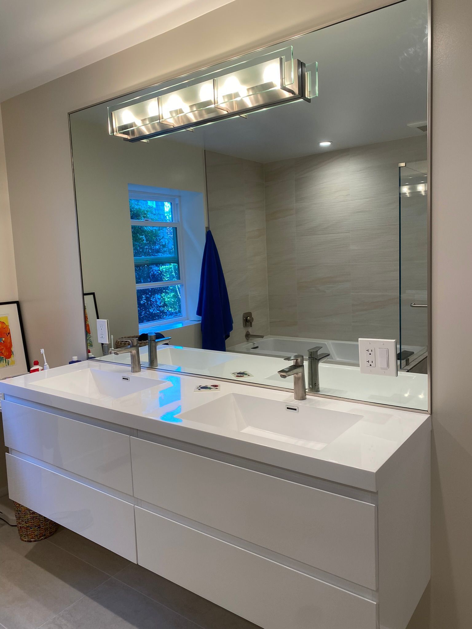 A bathroom with two sinks and a large mirror.