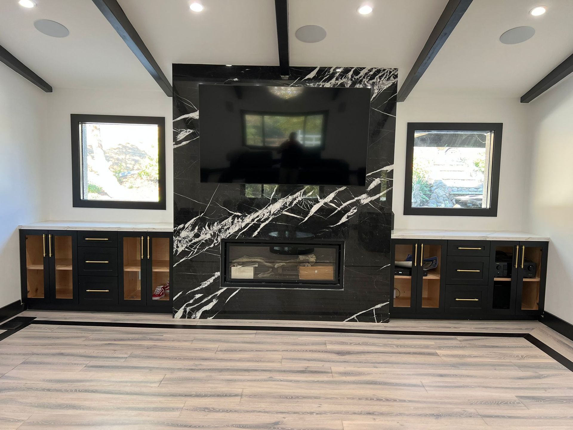 A living room with a fireplace and a flat screen tv on the wall.