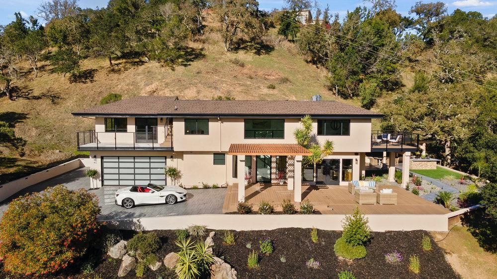 An aerial view of a large house with a car parked in front of it.