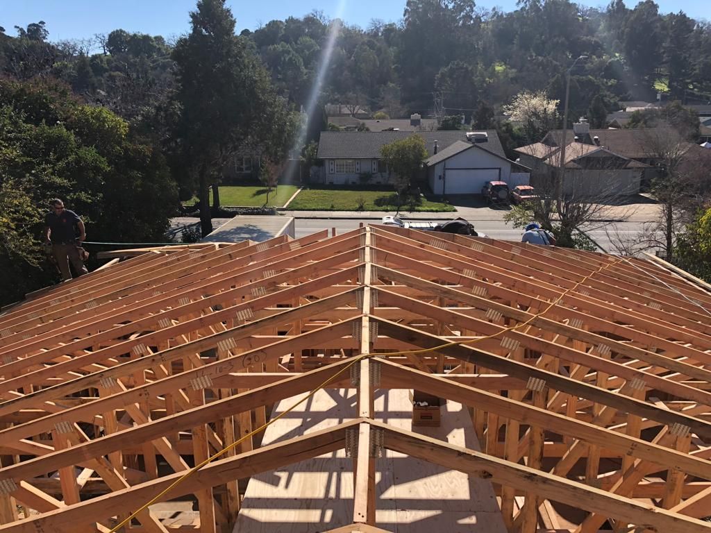 A large wooden structure is being built in a residential area.
