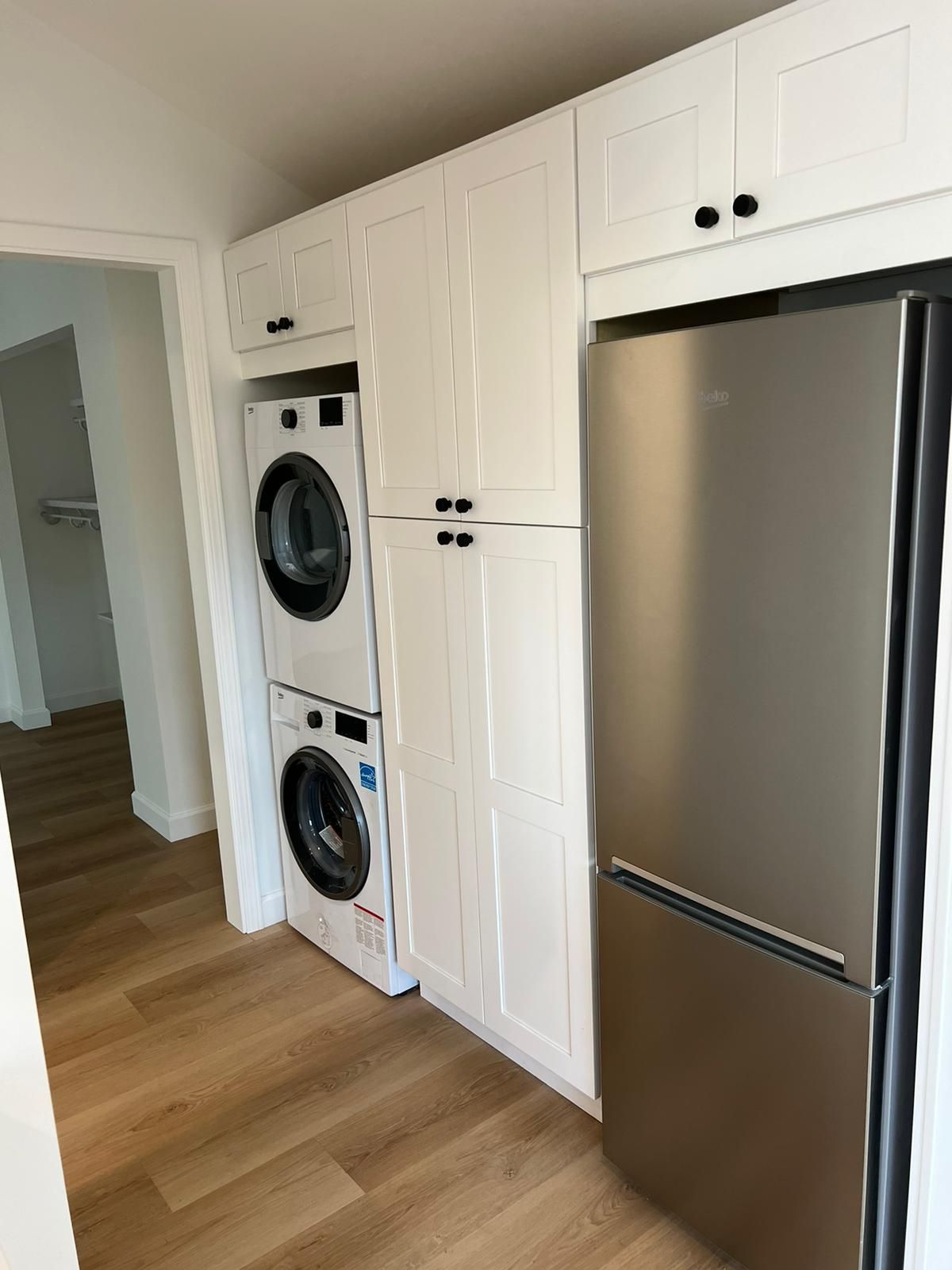A laundry room with a washer and dryer stacked on top of each other.