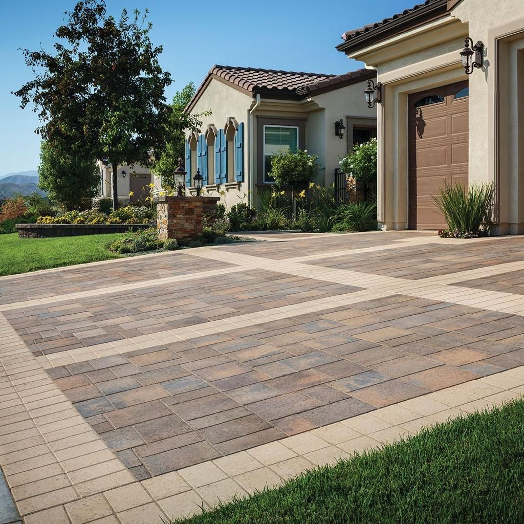 A driveway leading to a house with a brown garage door