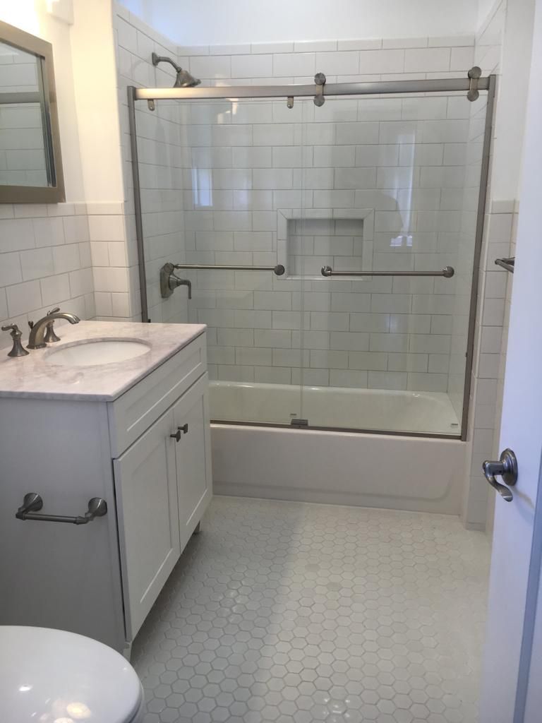 A bathroom with a sink , toilet and shower.