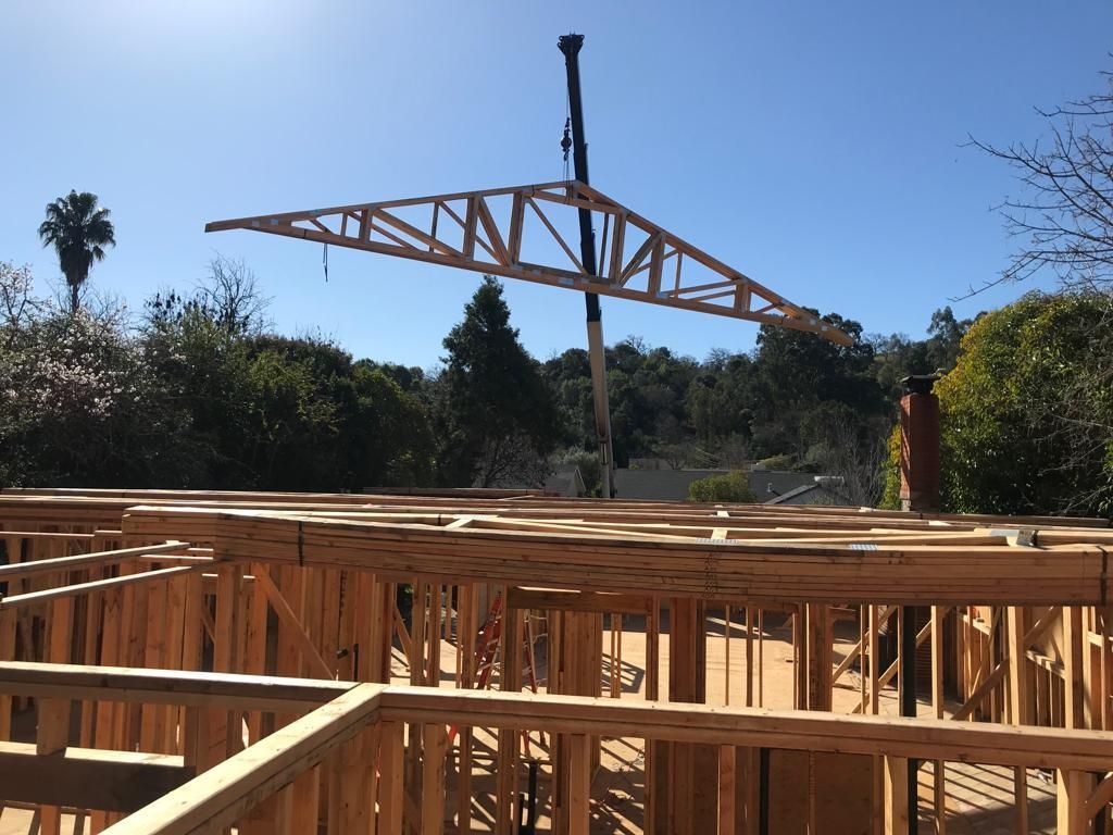 A large wooden structure is being built with a crane in the background
