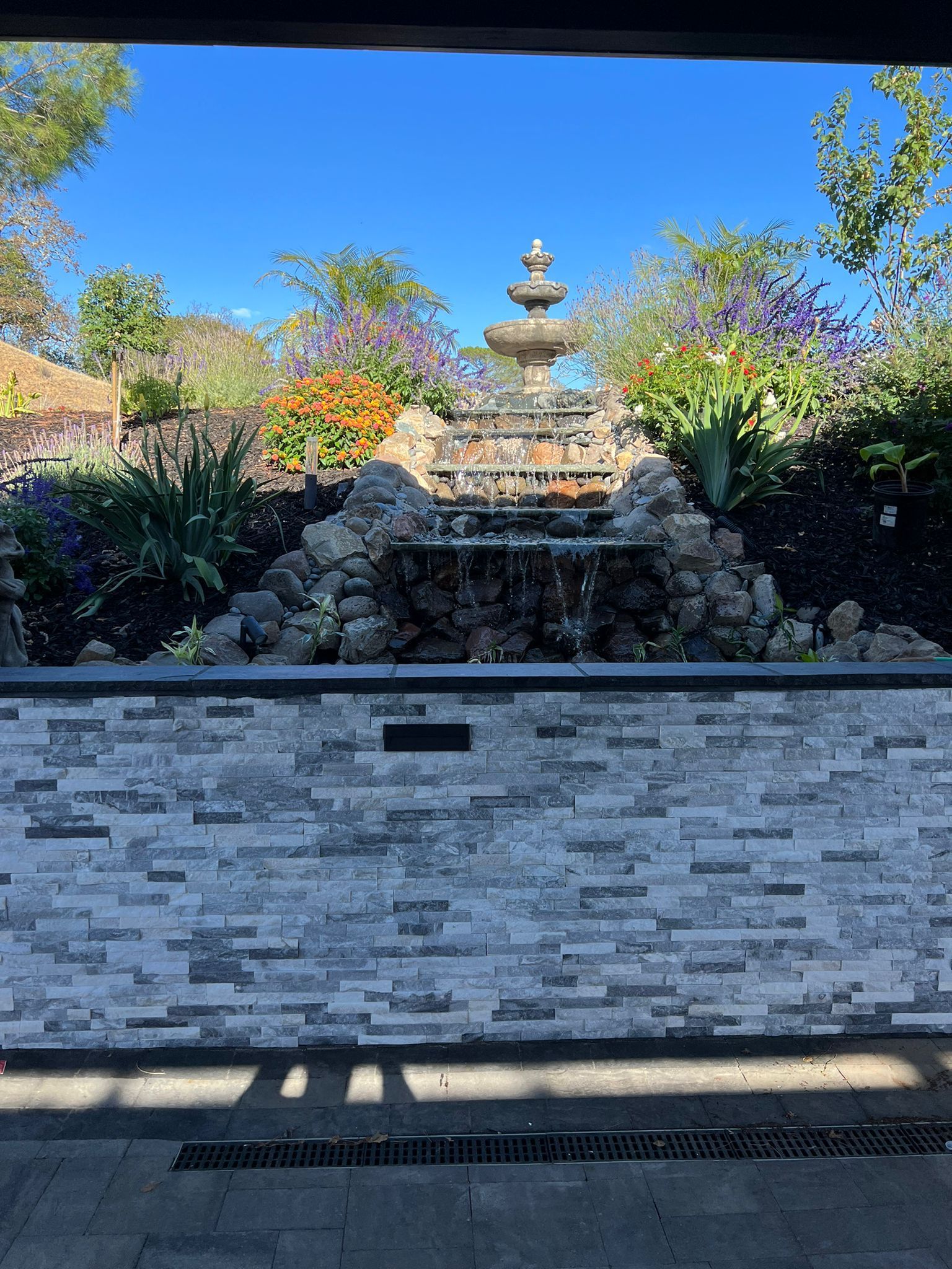 A brick wall with a waterfall in the background.