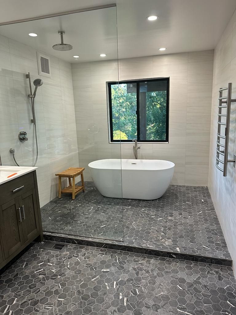 A bathroom with a tub , sink , and shower.