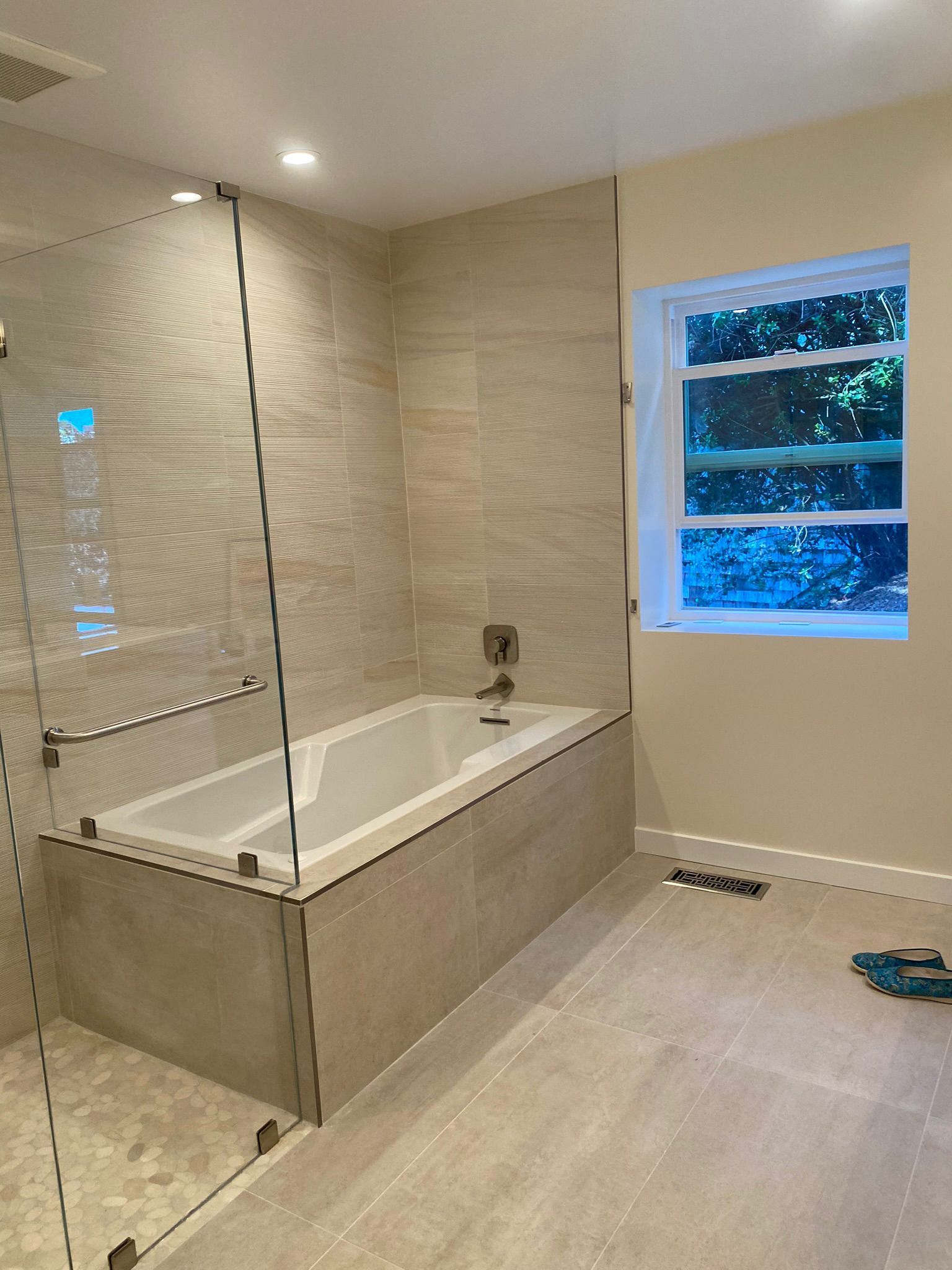A bathroom with a bathtub and a window.